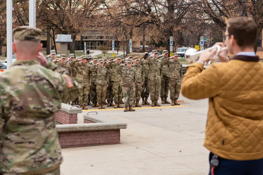 NDSU's annual Veterans Day program. Military members are standing at attention as Taps are played on the trumpet.